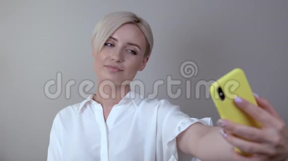 女孩伸出手臂自拍电话是黄色的视频的预览图