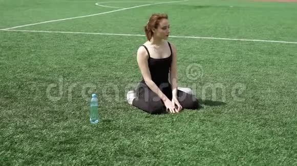 年轻漂亮的女人在做完根部运动后在草坪上休息视频的预览图