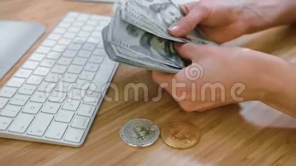 女人用比特币计算现金女人双手的侧视数着木制钞票上的大捆钞票视频的预览图