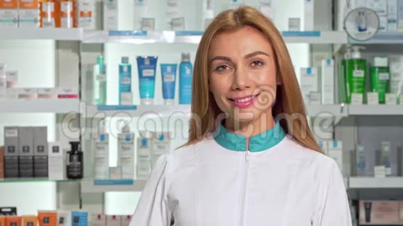 美丽的女药剂师微笑着拿着胶囊泡在药店里视频的预览图