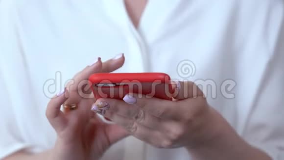 特写的女人手拿着一个红色的箱子里的电话拨通一个电话号码把电话带到耳朵里视频的预览图