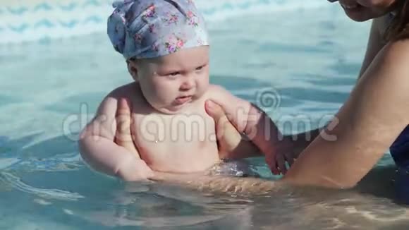 妈妈抱着女儿她在游泳池里玩得很开心视频的预览图