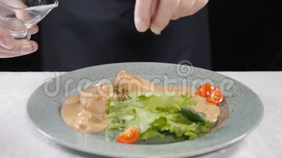 素食观念健康食品专业厨师在手套中加入牛油果切片烹饪健康沙拉视频的预览图