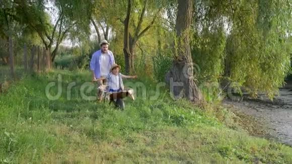 快乐的爸爸和他的小儿子在农村度假时在手推车里混视频的预览图