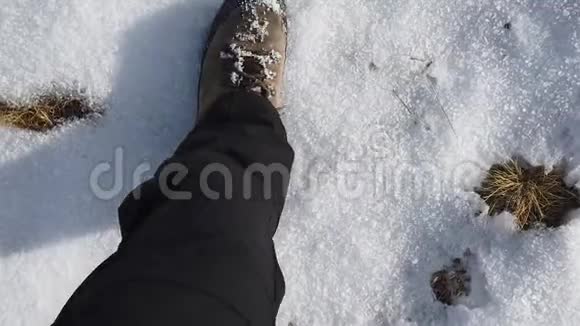 希克尔的观点在草地和雪地之间的山路上缓慢行走的特写镜头视频的预览图