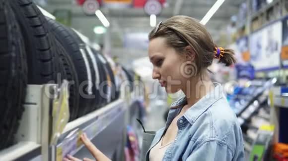 汽车配件部在店里大型超市那女孩提着轮胎站在架子旁边视频的预览图