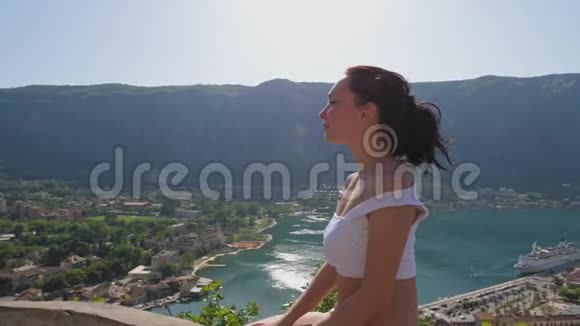 女孩坐在山上的高空休息视频的预览图