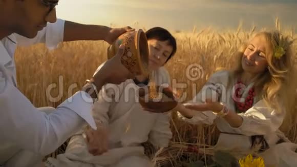 年轻的印第安人把泥锅里的谷物洒进木制碗里美丽的女人和另一个女人坐在一起视频的预览图
