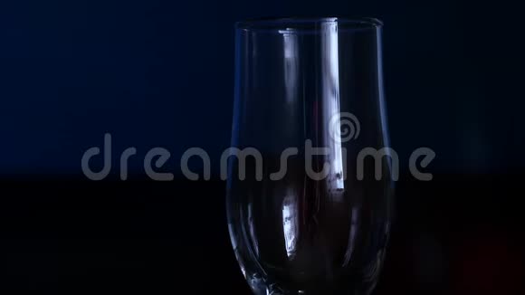 特写香槟在电视背景下流入玻璃杯慢动作视频的预览图