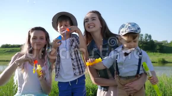 快乐的情绪笑着的孩子们一边吹着肥皂泡一边在大自然中放松视频的预览图