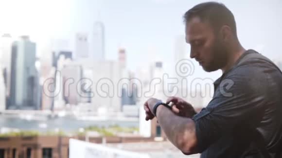 成功的欧洲商人微笑使用智能手表在史诗般的曼哈顿天际线纽约市交流视频的预览图
