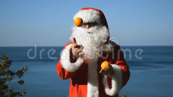 一个穿着圣诞老人服装的人在海边玩橘子旅行和度假视频的预览图
