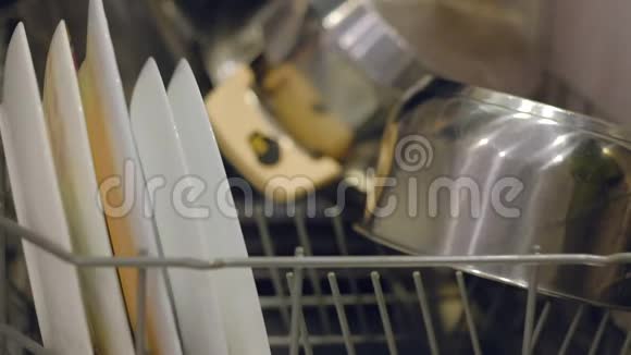 女人从洗碗机里拿盘子女人倒洗碗机干净的器皿排列在架子上女性视频的预览图