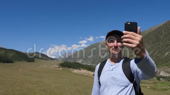 快乐旅行者用电话拍摄视频或山谷全景照片视频的预览图