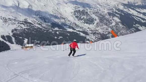 成熟的女子滑雪者在冬天滑下山坡踩刹车视频的预览图