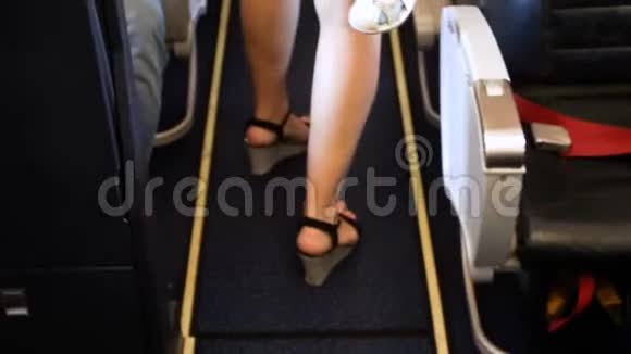 在客机上女性双脚在一排座位之间行走的特写镜头视频的预览图