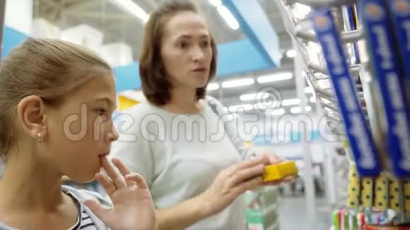 一个女孩和她妈妈在超市里选择蜡笔购买学习用品视频的预览图