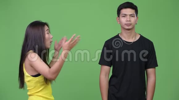 年轻的亚洲男人对年轻的愤怒的亚洲女人做手势视频的预览图