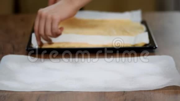 女性手从海绵蛋糕的底部剥离羊皮纸视频的预览图