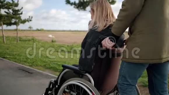 男子与残疾女孩在轮椅上行走视频的预览图