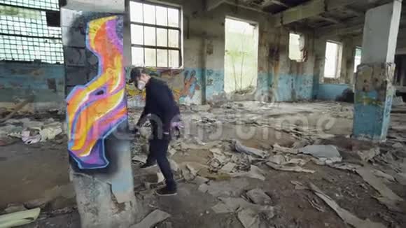 城市街头艺术家在废弃的房子里用肮脏的墙壁和窗户装饰旧柱子他用油漆视频的预览图