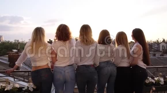 六个性感的年轻女子从背后一排排地站在露台上穿着休闲服白衬衫和视频的预览图