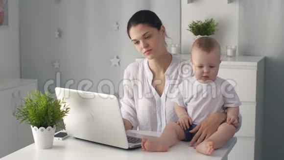 妈妈累了带着孩子在手提电脑视频的预览图