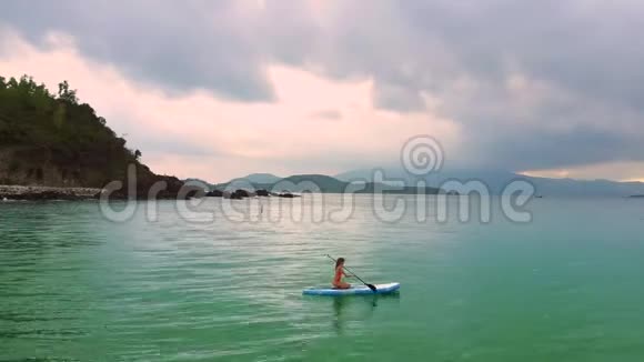 女孩坐在桨板上日出时出海视频的预览图