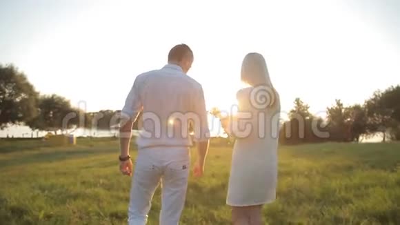 一对相爱的夫妇走在阳光的背景下视频的预览图