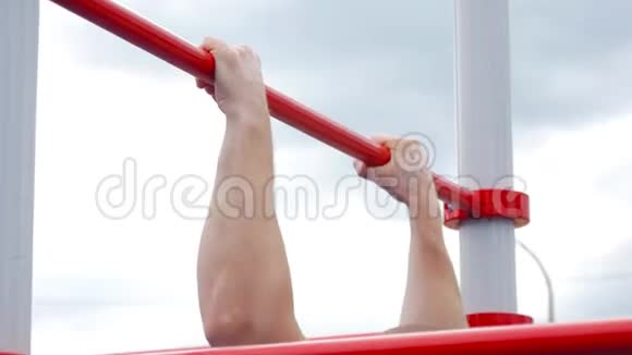 强壮的年轻人做拉力练习在户外的水平杆上做拉力运动的强壮运动员体育运动视频的预览图