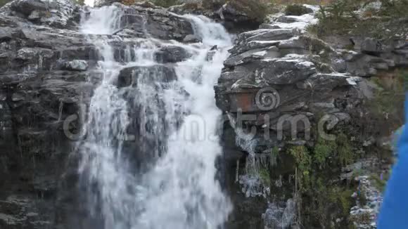 一个人在山上拍摄一个美丽的瀑布在相机上他过着活跃有趣的生活视频的预览图