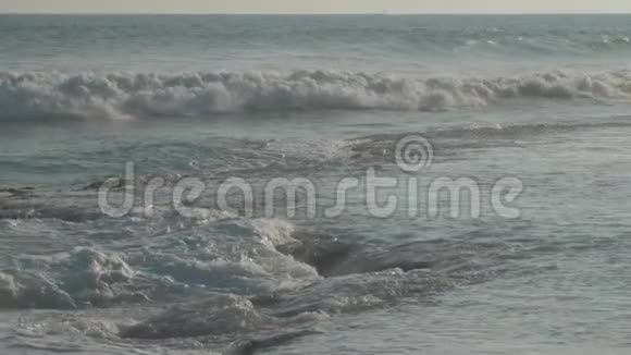 巨大的海浪在海滩上翻滚蓝天慢动作视频的预览图