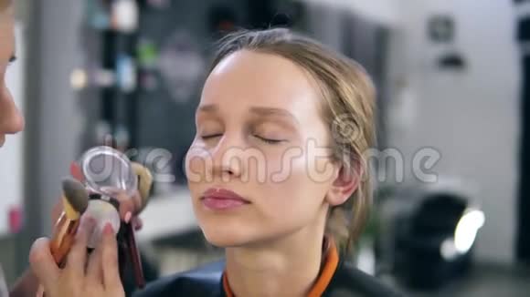 化妆师用闪亮的阴影做化妆口音用手指和刷子戴上脸鼻子化妆视频的预览图