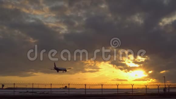 飞机着陆了夕阳西下另一架飞机在背景下飞向天空视频的预览图