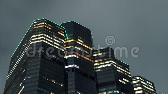 夏季夜晚明亮的摩天大楼云层反射在建筑表面视频的预览图