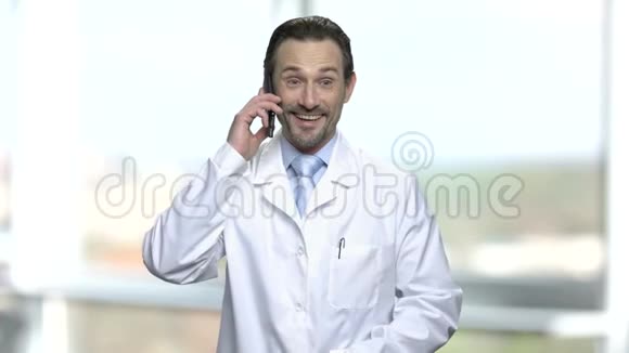 兴奋的成熟医生在手机上交谈视频的预览图