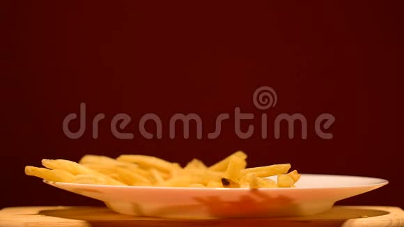 薯条倒在盘子里垃圾食品行业美味但不健康的小吃视频的预览图