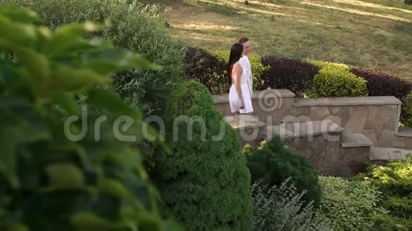 一对相爱的夫妇在日落时分走下楼梯在公园里散步视频的预览图