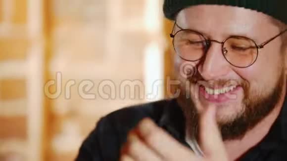 戴眼镜的胡子男在酒吧和他的朋友聊天关门视频的预览图