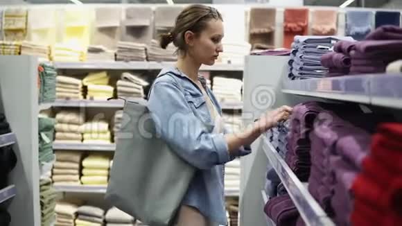 各种不同颜色的浴巾两排之间女性买家的侧视图打开毛巾视频的预览图