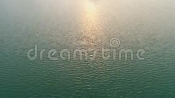 日落时高空飞过水面太阳轨道上的火花视频的预览图