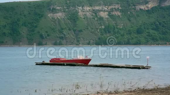 一艘红色的小救援船在河上与森林对着山视频的预览图