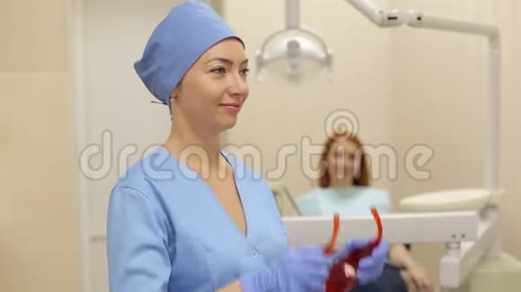 牙医在与病人合作前戴上防护橙色眼镜视频的预览图