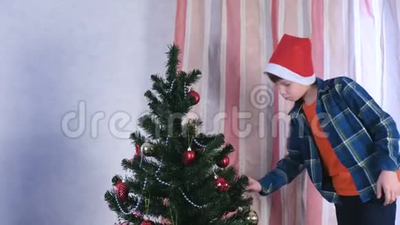 母亲和儿子戴着圣诞帽把尖顶放在圣诞树上视频的预览图