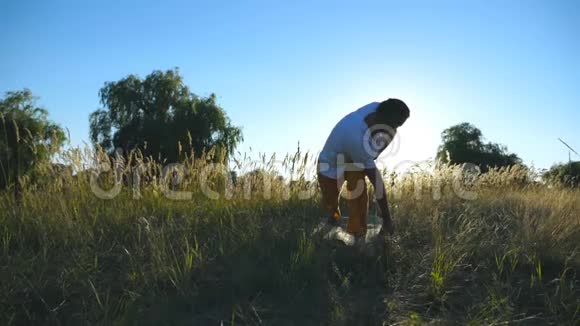 运动男子站在瑜伽姿势在垫子在草地上在阳光明媚的夏日里年轻人在野外训练夏季视频的预览图