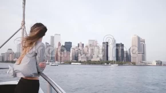 快乐的女商人头发随风飘动在船上慢悠悠地观赏纽约曼哈顿的壮丽天际视频的预览图