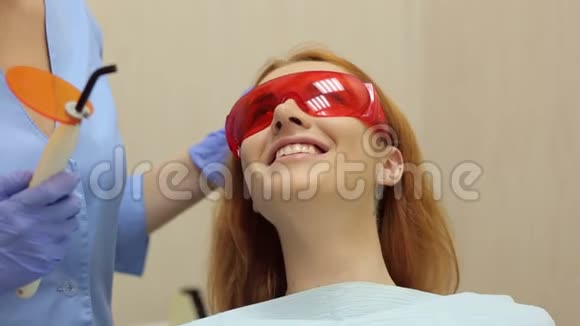 一个女孩的特写躺在安全眼镜的牙科椅上视频的预览图