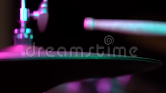 鼓槌击中高帽关闭侧观霓虹粉蓝彩彩光慢动作音乐概念视频的预览图