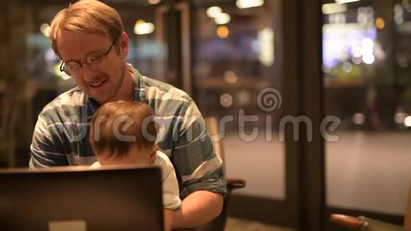 父子俩一起用笔记本电脑视频的预览图
