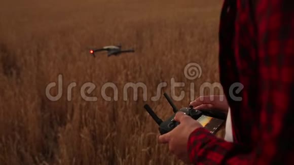 农夫双手握着遥控器四架直升机在后台飞行无人飞翔飞翔视频的预览图